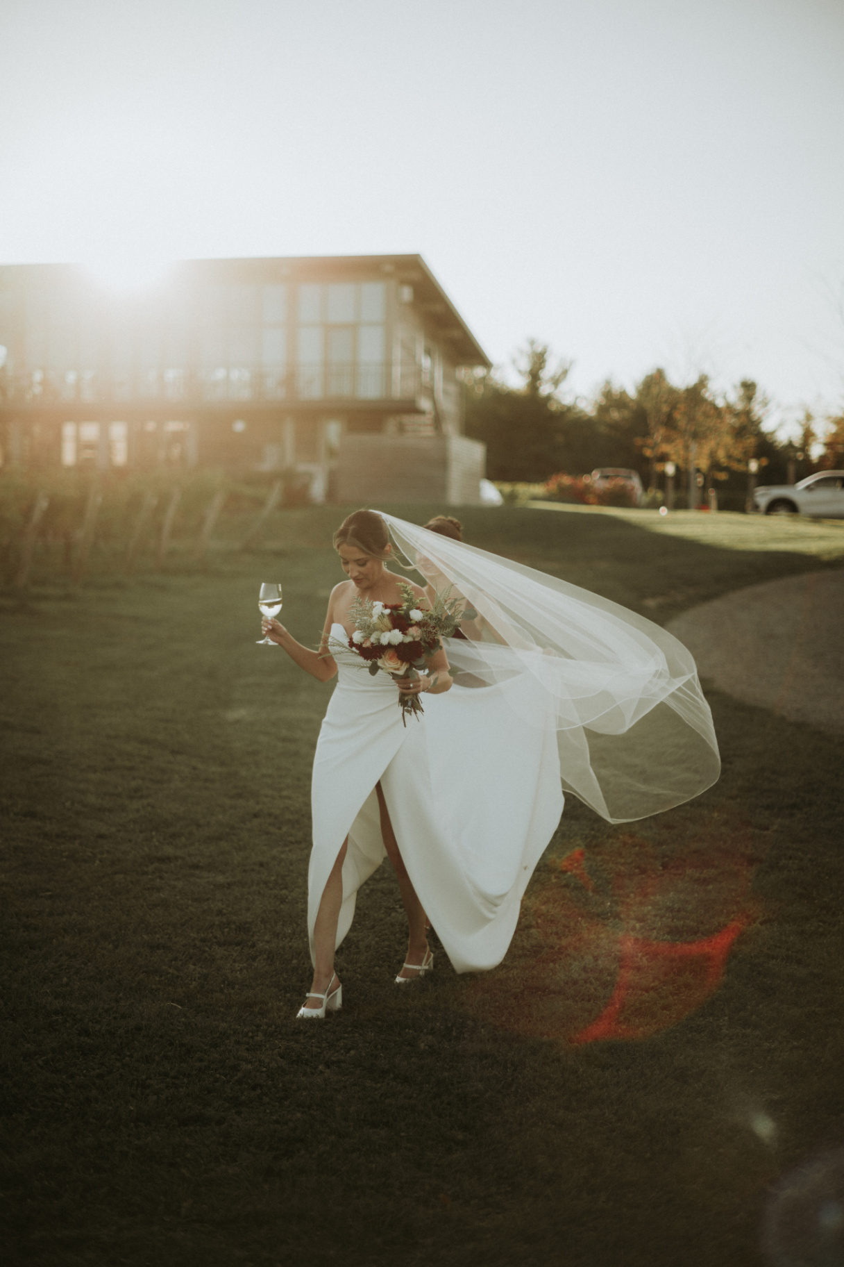 Bride with veil catching the wind at sunset