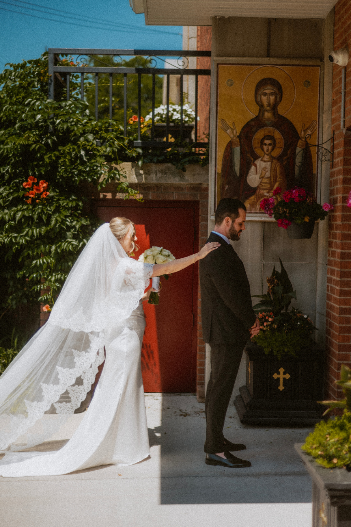 Bride and groom pausing at a church entrance